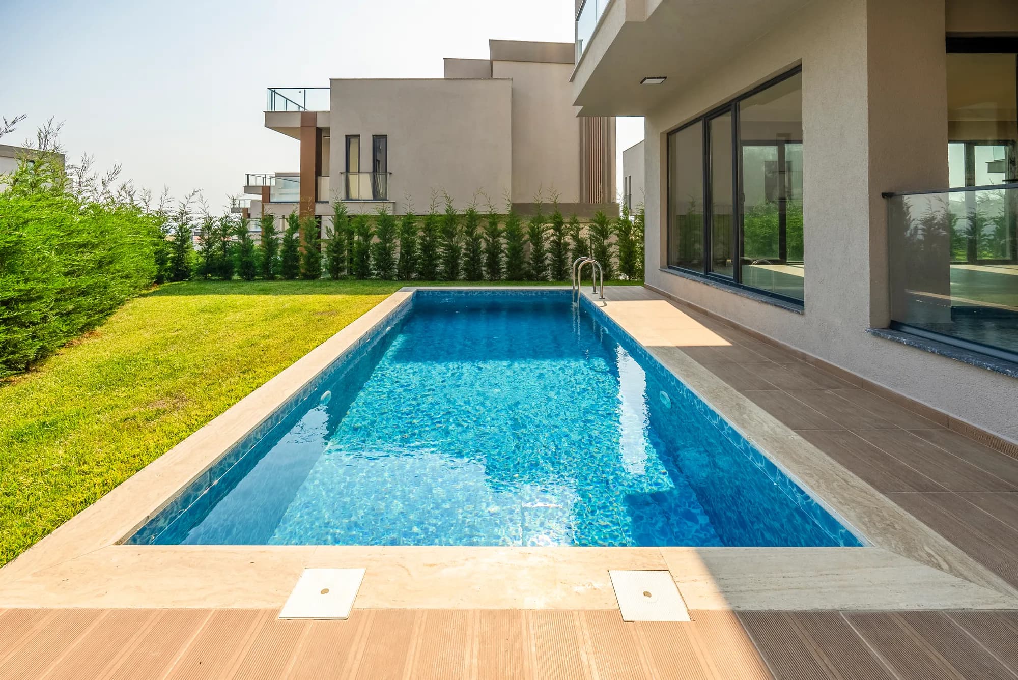 Villa pool on an open lawn in strong sun, Istanbul (Turkey)