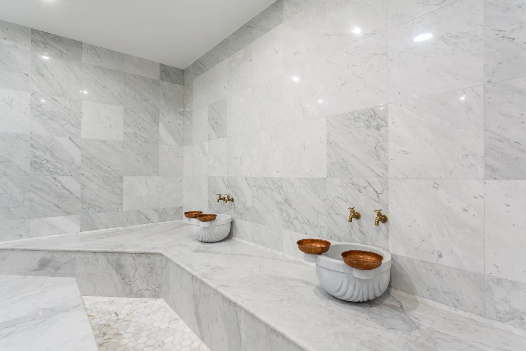 Compact hammam in cream marble with round basins