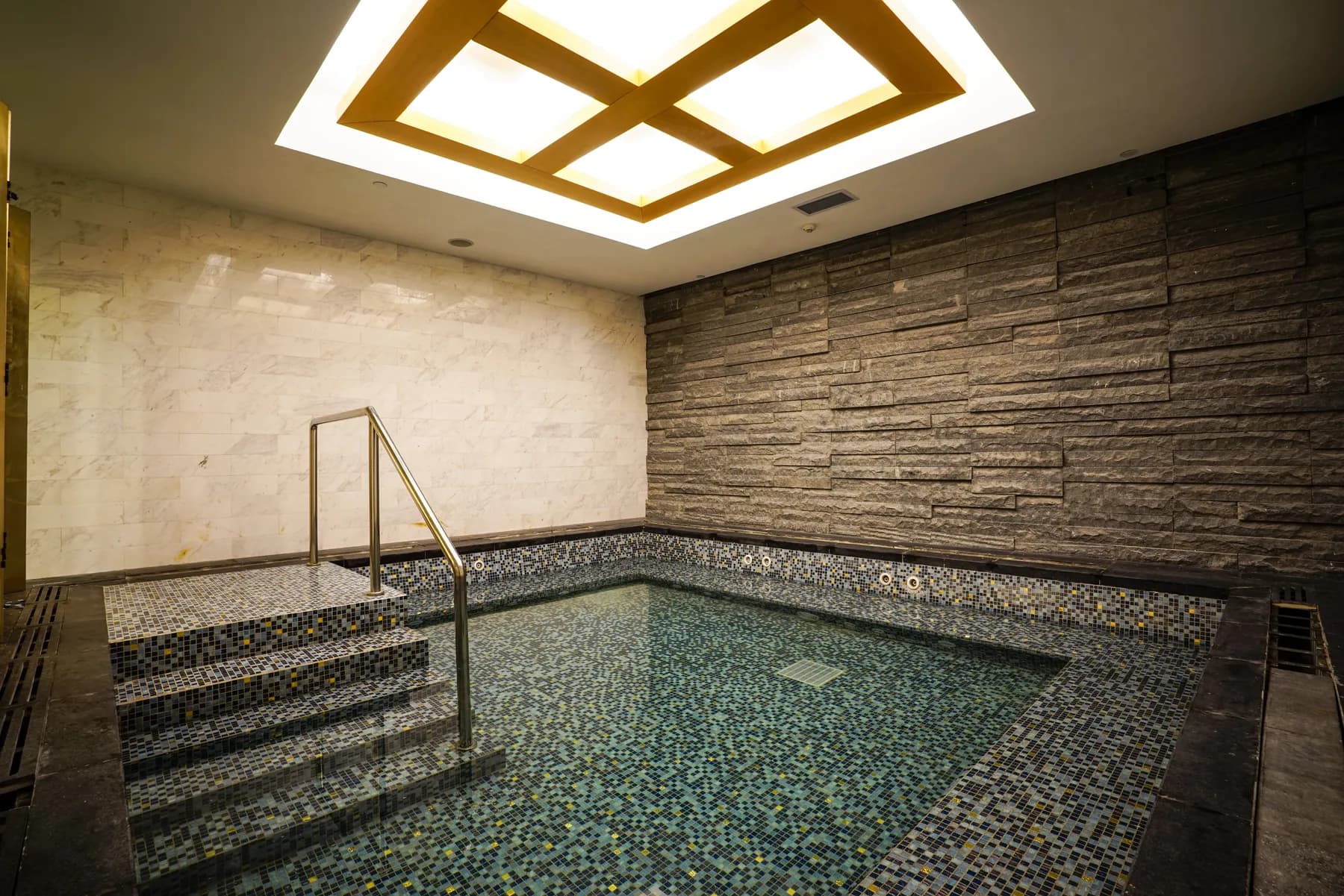 Bassin d'hydromassage habillé de mosaïque avec marches