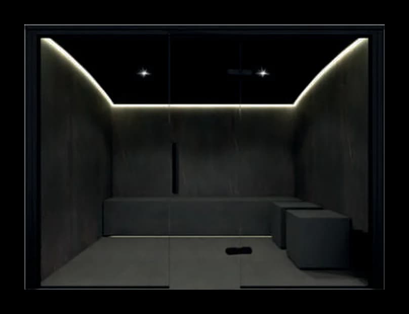 Hammam Asana vu de face, façade vitrée, parois en porcelaine noire, plafond voûté à bandes LED, banc et 2 poufs